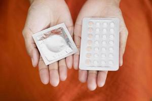 donna è utilizzando nascita controllo pillole e preservativi. foto