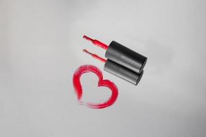 il cuore è dipinto con rosso gel polacco su il specchio. spazzola con rosso gel chiodo polacco foto