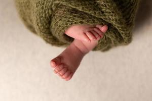 neonato bambino piedi su un fiocchi d'avena sfondo avvolto nel un' a maglia coperta foto