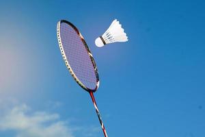 badminton racchetta e bianca volano su il blu sfondo di il cielo. morbido e selettivo messa a fuoco. foto
