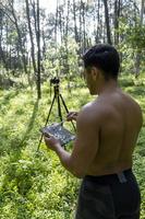 maturo di mezza età atleta uomo in piedi nel In piedi posizione nel sportivo Abiti su fitness stuoia, Guardando video formazione lezione in linea, Vlogging foto