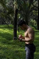 attivo bello maschio yogi passeggiate nel un' parco passeggiando foresta prima o dopo un' allenamento. giovane ispanico atletico uomo yoga classe con un' fitness stuoia foto