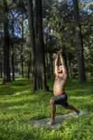 latino americano uomo fare yoga postura, yoga postura, ape indietro prstata brahmara, foresta foto