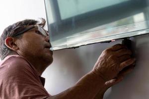 messicano latino uomo riparazione un' tv schermo, controllo per difetti. foto