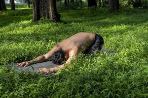 latino americano uomo fare yoga postura, yoga postura, ape indietro prstata brahmara, foresta foto