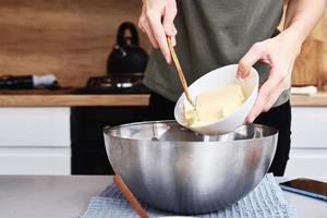 mani mettere burro nel un' ciotola. cucinando ricetta foto