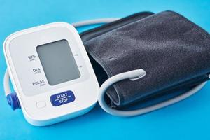digitale sangue pressione tenere sotto controllo su un' blu sfondo, avvicinamento. helathcare e medico concetto foto