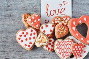 decorato e smaltato cuore forma biscotti e carta Nota con iscrizione amore su il grigio sfondo, superiore Visualizza. san valentino giorno concetto foto