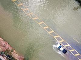 allagato strade, persone con macchine in esecuzione attraverso. aereo fuco fotografia Spettacoli strade allagamento e persone macchine passaggio di, spruzzi acqua. foto