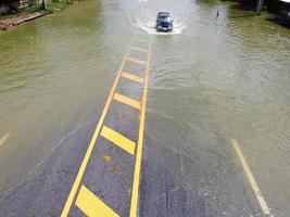 allagato strade, persone con macchine in esecuzione attraverso. aereo fuco fotografia Spettacoli strade allagamento e persone macchine passaggio di, spruzzi acqua. foto