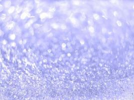 ispirato di di moda molto peri colore di il anno 2022. astratto sfocato leggero viola scintillante bokeh. brillante neve struttura su un' inverno soleggiato giorno. Natale e nuovo anno sfondo. posto per testo. foto