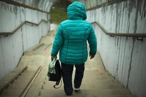 il donna va giù il scale. un' donna nel Russia passeggiate lungo un alto passaggio al di sopra di il autostrada. foto