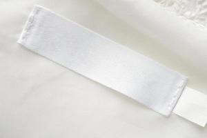 vuoto bianca lavanderia cura Abiti etichetta su tessuto struttura sfondo foto