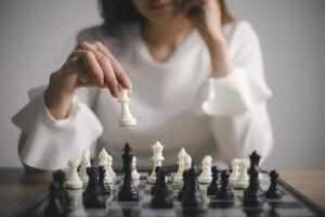 donna d'affari giochi con scacchi gioco. concetto di attività commerciale strategia e tattica. strategia, gestione, o comando concetto foto