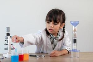 formazione scolastica, scienza, chimica e bambini concetto - bambini o studenti con test tubo fabbricazione sperimentare a scuola laboratorio foto