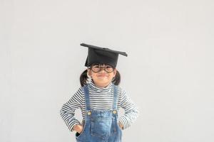 contento asiatico scuola ragazzo diplomato nel la laurea berretto foto