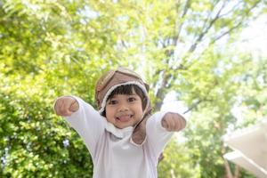 un' carino poco ragazza vestito nel un' berretto e bicchieri di un' pilota. il bambino sogni di diventare un' pilota. foto