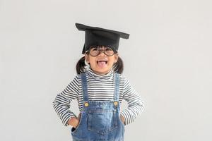 contento asiatico scuola ragazzo diplomato nel la laurea berretto foto