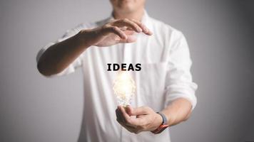 maschio mano Tenere illuminato leggero lampadina, nuovo idea, innovazione e ispirazione concetto, e idee parola foto