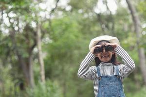 contento ragazzo guardare avanti. sorridente bambino con il binocolo. viaggio e avventura concetto. libertà, vacanza foto