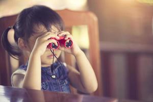 asiatico carino poco ragazza binocolo giocattolo foto