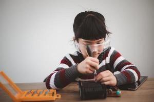 gli studenti asiatici imparano a casa a codificare auto robot e cavi di schede elettroniche in stelo, vapore, matematica ingegneria scienza tecnologia codice informatico in robotica per bambini concetto. foto