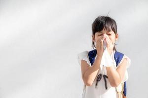 asiatico bambino ragazza malato con starnuti su il naso e freddo tosse su fazzoletto di carta carta perché debole o virus e batteri a partire dal polvere tempo metereologico foto