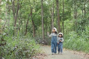bambini siamo intestazione per il famiglia campeggio nel il foresta camminare lungo il turista percorso. campeggio strada. famiglia viaggio vacanza concetto. foto