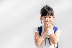 asiatico bambino ragazza malato con starnuti su il naso e freddo tosse su fazzoletto di carta carta perché debole o virus e batteri a partire dal polvere tempo metereologico foto