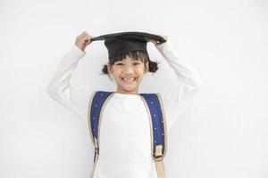 contento asiatico scuola ragazzo diplomato con la laurea berretto foto