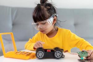 gli studenti asiatici imparano a casa a codificare auto robot e cavi di schede elettroniche in stelo, vapore, matematica ingegneria scienza tecnologia codice informatico in robotica per bambini concetto. foto