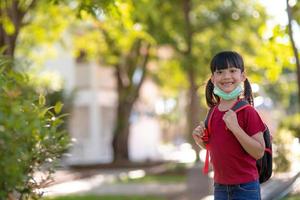 scuola bambino indossare un' viso maschera durante coronavirus e influenza scoppio. fratello ragazza andando indietro per scuola dopo covid-19 quarantena e confinamento. bambini nel maschere per coronavirus prevenzione.soft messa a fuoco foto