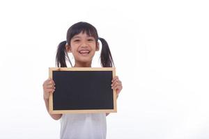poco asiatico bambino mostrare il nero tavola su isolato sfondo foto