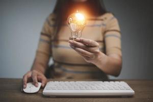mano di donna Tenere illuminato leggero lampadina, idea, innovazione e ispirazione concetto.concetto creatività . foto