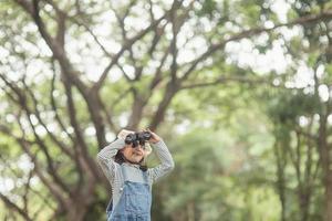 contento ragazzo guardare avanti. sorridente bambino con il binocolo. viaggio e avventura concetto. libertà, vacanza foto