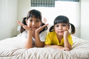 carino asiatico bambini dire bugie su il letto foto