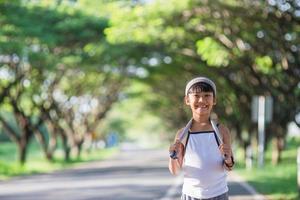 contento bambino ragazza in esecuzione nel il parco nel estate nel natura. caldo luce del sole bagliore. asiatico poco è in esecuzione nel un' parco. all'aperto gli sport e fitness, esercizio e concorrenza apprendimento per ragazzo sviluppo. foto