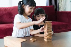 Due asiatico ragazza giocando di legno pile a casa foto