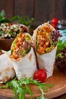 burritos avvolge con carne macinata di manzo e verdure su un fondo di legno foto