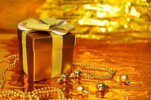 confezione regalo dorata su sfondo lucido foto