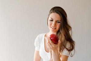 bellissimo casuale caucasico donna è di per mordere un Mela nel cucina, un' giovane foto