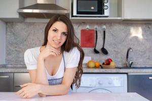 caucasico donna casalinga è in piedi nel il cucina a casa mantelli se stessa foto