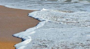 onde che si infrangono sulla spiaggia foto