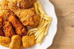 pollo fritto con patatine fritte e pepite sul piatto foto