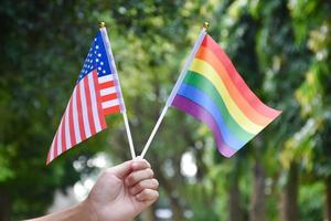 arcobaleno bandiera e unito stati di America nazionale bandiera Tenere nel mano, morbido e selettivo messa a fuoco, concetto per celebrazione di LGBTQ più nel orgoglio mese foto