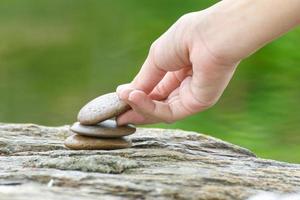 mano mettere pietra edificio un' mucchio di zen pietre foto