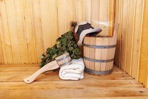 dettagli interni sauna finlandese bagno turco con accessori per sauna tradizionali bacino di betulla scopa paletta cappello di feltro asciugamano. concetto di spa tradizionale vecchio stabilimento balneare russo. rilassare il concetto di bagno del villaggio di campagna. foto