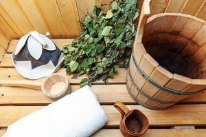 dettagli interni sauna finlandese bagno turco con accessori per sauna tradizionali bacino di betulla scopa paletta cappello di feltro asciugamano. concetto di spa tradizionale vecchio stabilimento balneare russo. rilassare il concetto di bagno del villaggio di campagna. foto