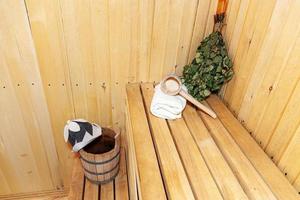 dettagli interni sauna finlandese bagno turco con accessori per sauna tradizionali bacino di betulla scopa paletta cappello di feltro asciugamano. concetto di spa tradizionale vecchio stabilimento balneare russo. rilassare il concetto di bagno del villaggio di campagna. foto