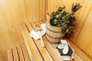 dettagli interni sauna finlandese bagno turco con accessori per sauna tradizionali bacino di betulla scopa paletta cappello di feltro asciugamano. concetto di spa tradizionale vecchio stabilimento balneare russo. rilassare il concetto di bagno del villaggio di campagna. foto